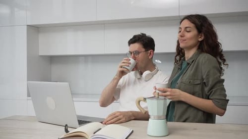Young Couple Using Laptop While Drinking Coffee