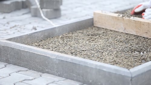 Leveling Gravel a Wooden Board