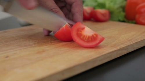 Tomato Slicing with Knife on Cutting Board