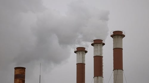 Smokestacks Billowing Smoke Against Overcast Sky