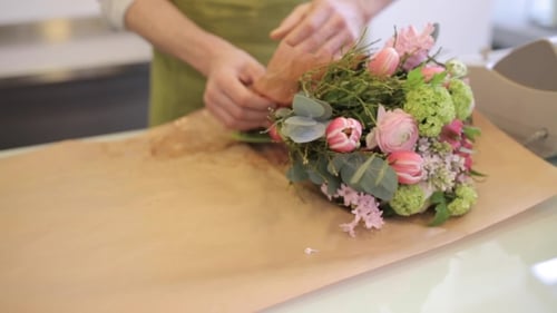 Florist Wrapping Flowers In Paper At Flower Shop 11