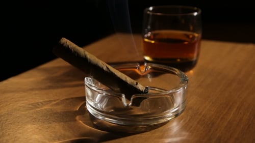 Whiskey and Cigar on Wooden Table at Night