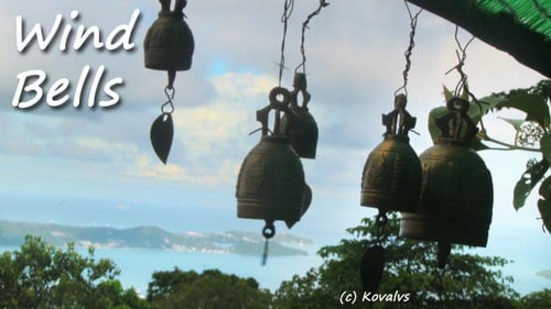 Ornate Bells Hanging Above Tropical Turquoise Bay