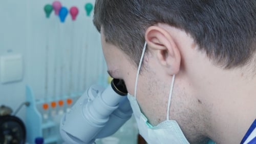 Of a Young Doctor Or Laboratory Researcher Looking Through The Eyepiece Of a Microscope.