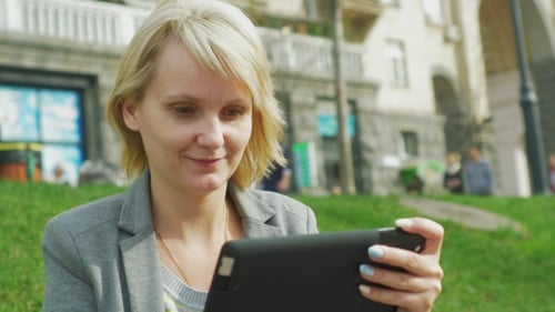 Woman Using Tablet Outdoors in the City