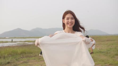 Woman Holding Garbage Bag at Community Cleanup Event