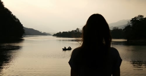 Silhouette of a Girl on a Background of Lake And Boat