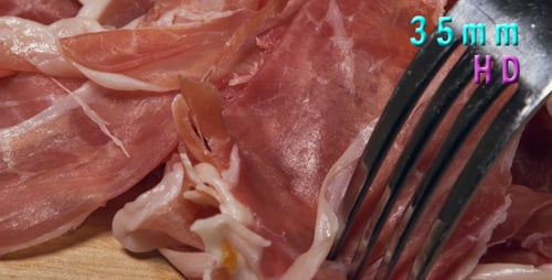 Thin Slices of Prosciutto Picked Up By a Fork