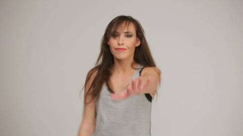 Expressive Young Woman Dancing on a Gray Background