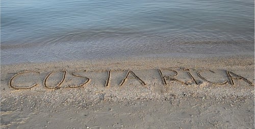 Costa Rica Written on Sandy Beach by Waves