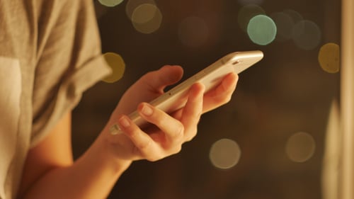 Woman Using Smartphone at Night in Urban Setting