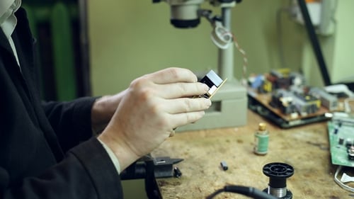 Man Working on Circuit Board with Soldering Iron
