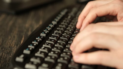 Mann arbeitet am Computer und tippt auf Tastatur