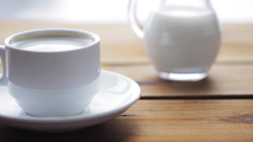 Coffee Stirred in White Cup with Milk