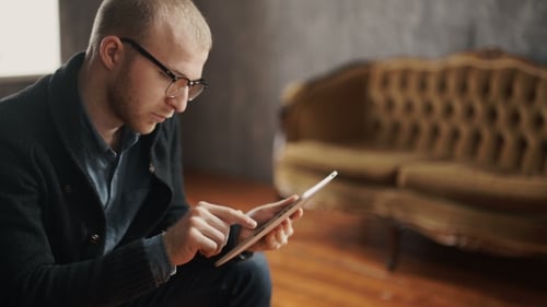 Young Man Using Tablet Device Indoors