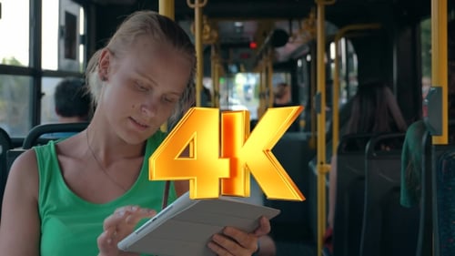 Young Woman Entertaining With Pad During Bus Ride