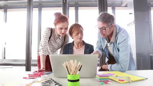 Design Team Collaborating on Laptop in Office