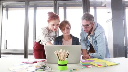 Team Collaborating on Laptop in Modern Office