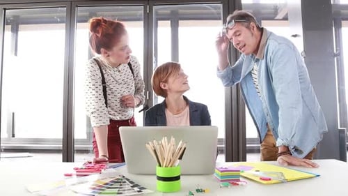 Creative Team Collaborates on Laptop in Modern Office