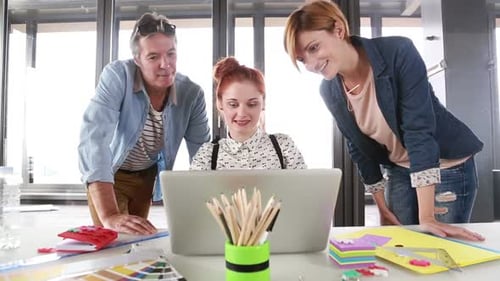 Team Collaborating on Laptop in Modern Office