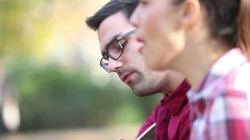 Junge brünette Frau singt, während Mann neben ihr sitzt Gitarre spielt 1