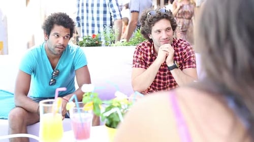 Zwei männliche Freunde sitzen im Sommer auf der Terrasse Café 2