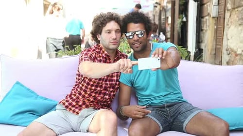 Two Men Using Smartphone Together Outdoors