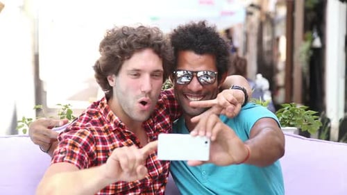 Two Friends Smiling Together While Taking a Selfie