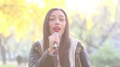 Woman Singing into Microphone in Autumn Park
