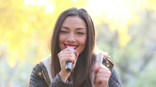 Woman Singing into Microphone in Natural Setting