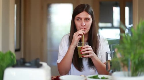 Young Woman Drinking Green Smoothie