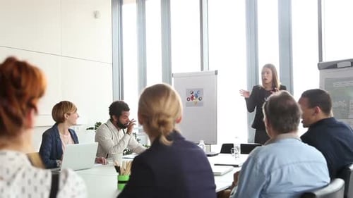 Woman Giving Presentation to Colleagues in Modern Office