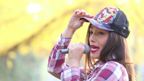 Woman Singing with Microphone in Park