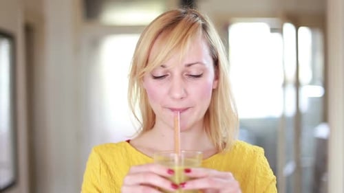 Blonde Woman Drinks Green Smoothie Indoors