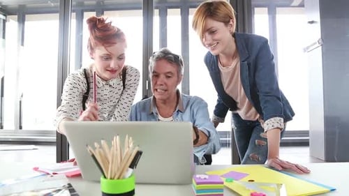 Colleagues Collaborating at a Desk with Laptop