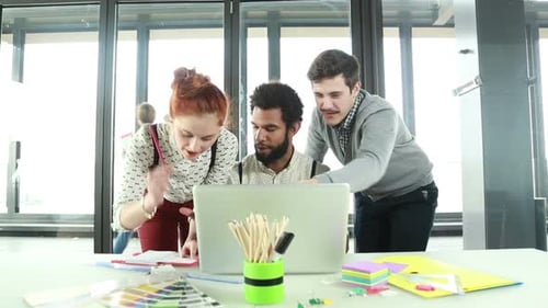 Team Collaboration on Laptop in Modern Urban Workplace
