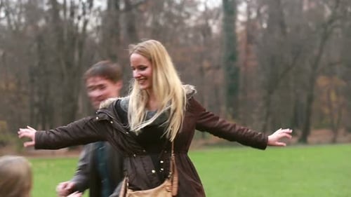 Father And Daughter Playing Around Mother In Park