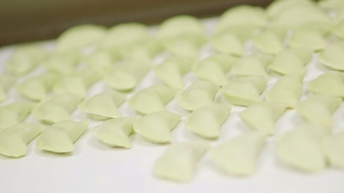Freshly Prepared Green Dumplings on White Surface