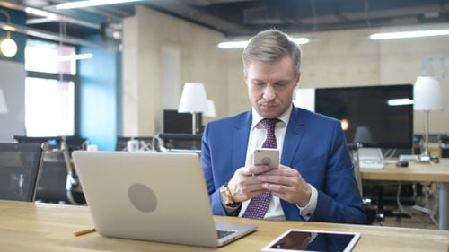 Geschäftsmann schreibt Textnachricht auf Smartphone