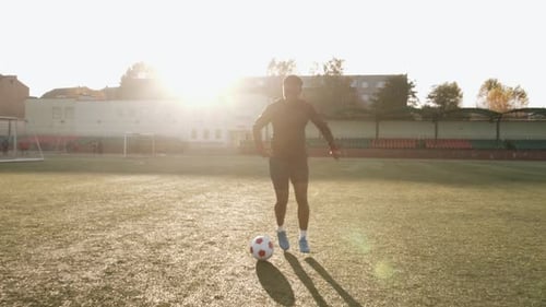 Man Dribbles Soccer Ball on a Sunny Day
