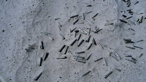 Empty Cases From Automatic Weapons Remaining In The Sand After The Fight
