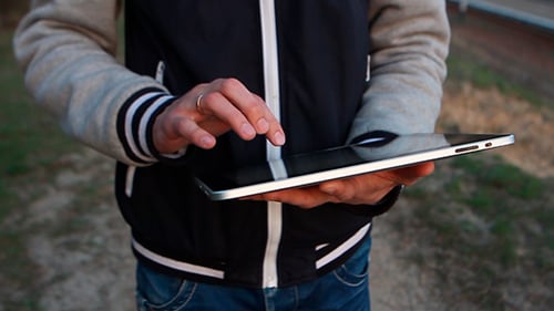 Man Walks On The Street And Using Tablet