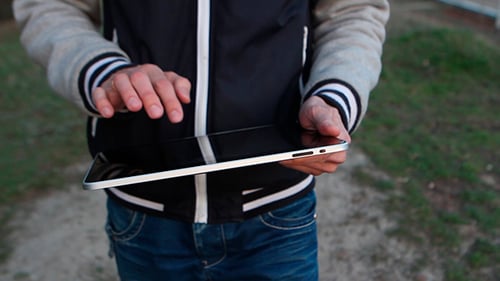Mann geht auf der Straße und benutzt Tablet