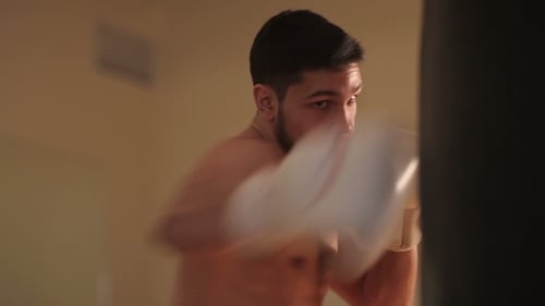 Junger Mann beim Boxen mit einem Boxsack