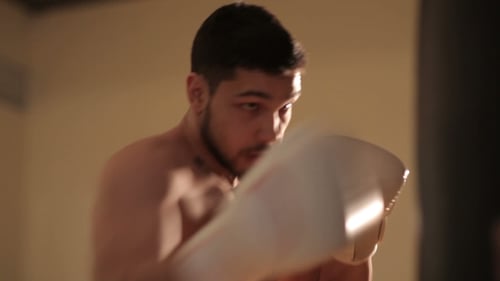 Young Man Practicing On a Punching Bag