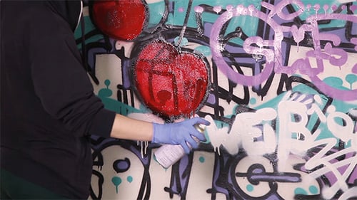 Jovem pinta um grafite