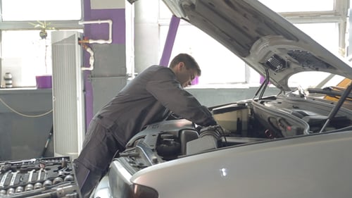 Homme réparant la voiture dans le garage