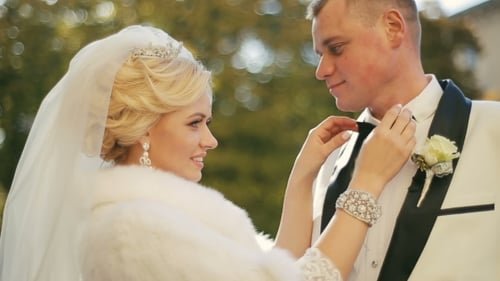 Bride Adjusting Groom's Bow Tie on Wedding Day