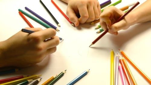 Hands Drawing Together with Colorful Pencils
