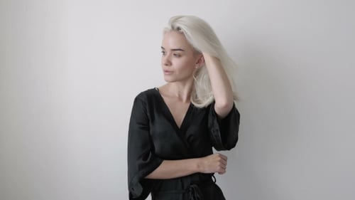 Blonde Woman Posing in Black Robe Against White Background